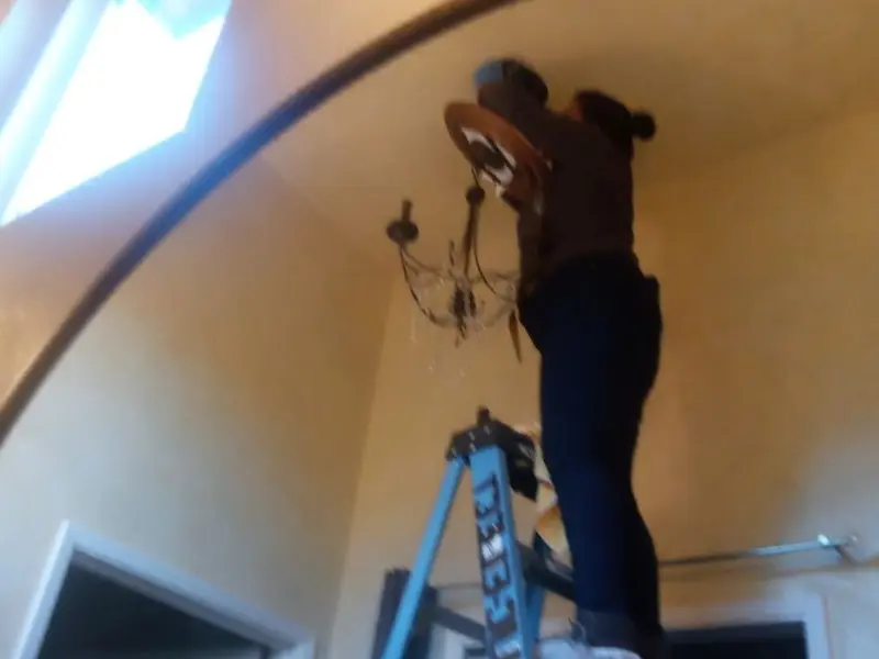 Electrician installing a chandelier in a Rio Dell residence